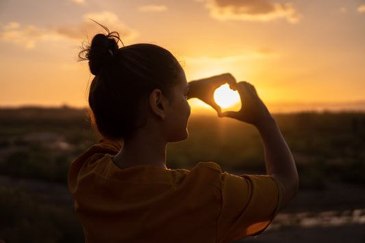 happy woman admiring sunset feeling empowered and fulfilled in her life and goals by using crystals