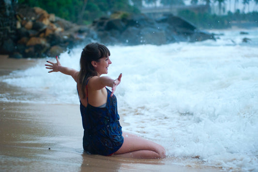 fulfilled and happy woman showing love, joy and acceptance on the beach having aligned her chakras and embraced the chakra meanings